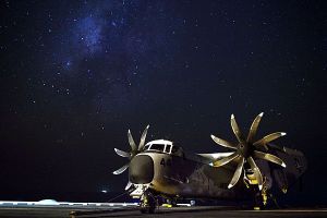 A COD sits aboard the USS Enterprise beneath a star-strewn night sky. (U.S. Navy photo by Mass Communication Specialist 2nd Class Brooks B. Patton Jr./Released)